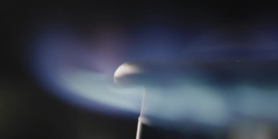Flames rise on the burner of a gas stove