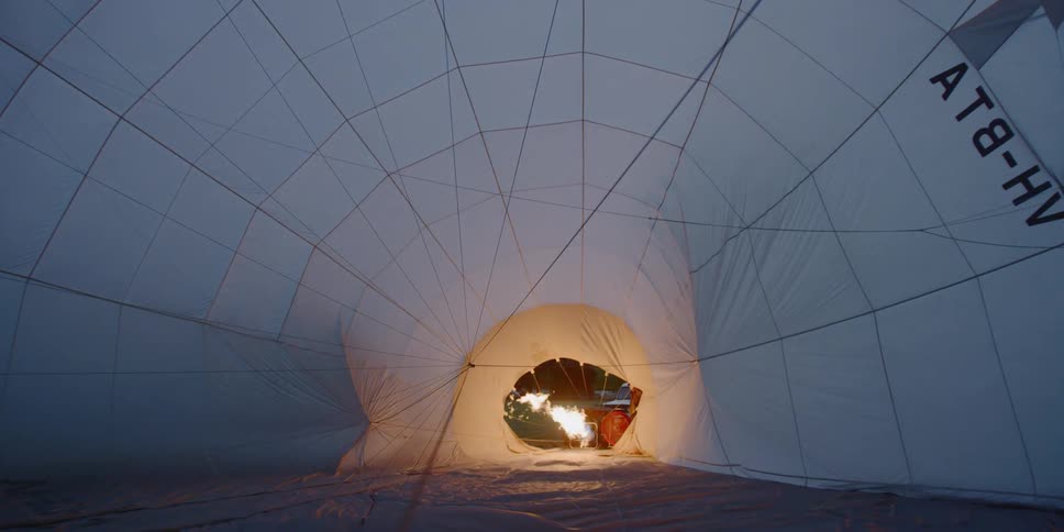 Fire burns at the entrance to a large white tent