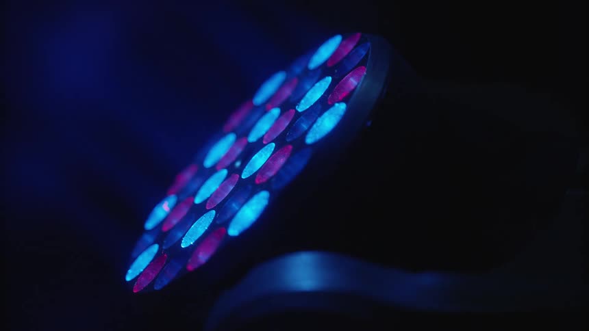 A stage light shines in the darkness