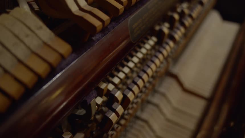 The hammers and pins of a piano move as keys are played