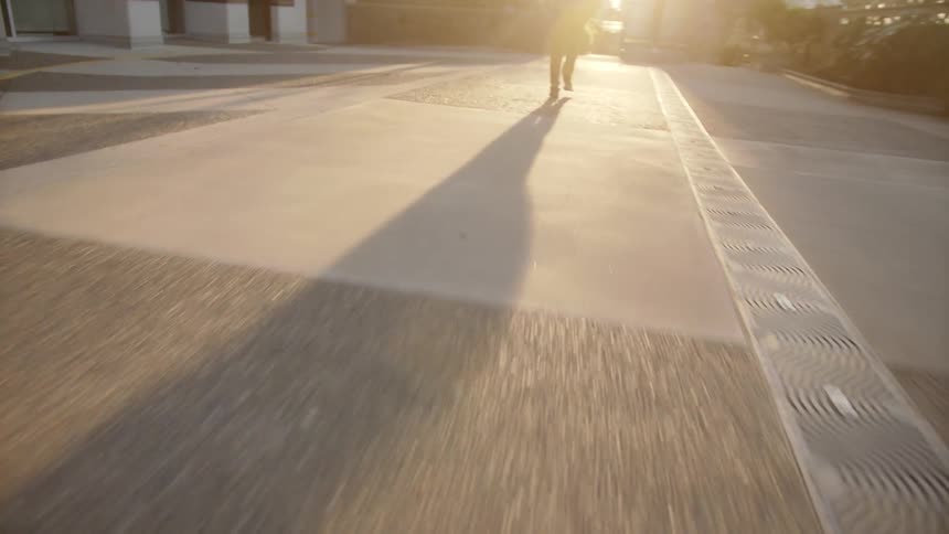 Man runs outdoors along the concrete floor at sunset