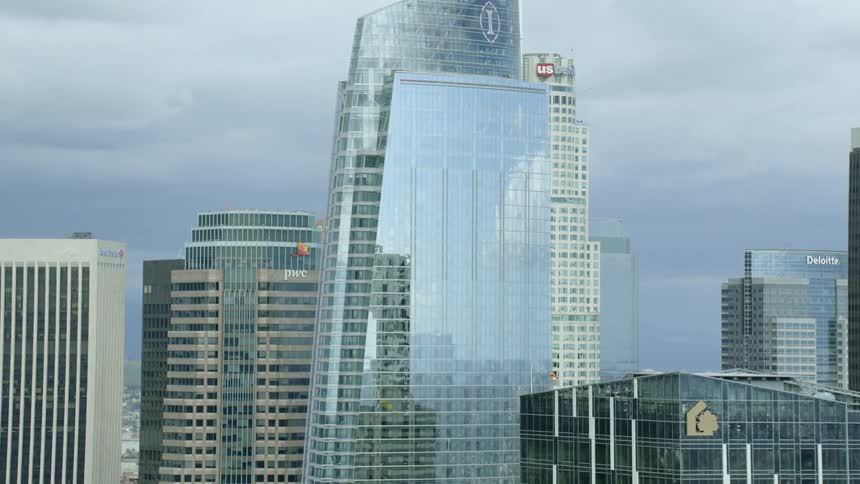 Window glass on skyscrapers reflects the cloudy sky