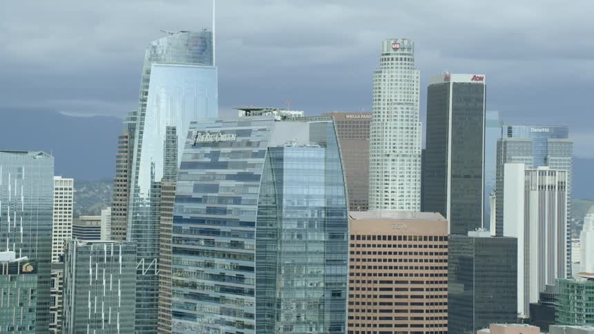 Skyscrapers tower over city center with mountain on the horizon