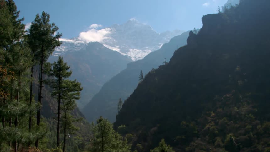 Tall mountain peaks over clouds in mountain range