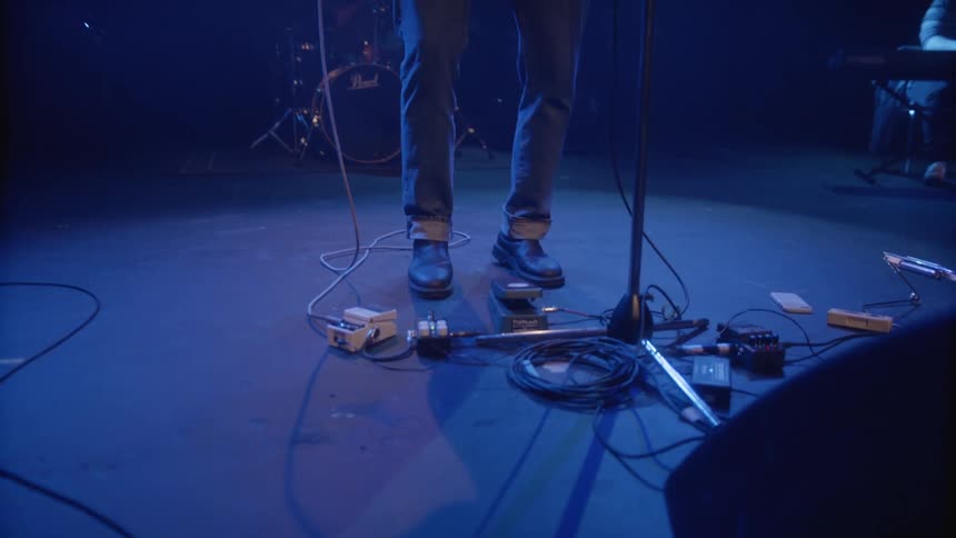 A guitarist plays on a stage