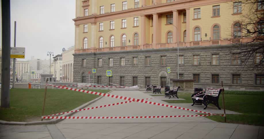 A sidewalk is cordoned off with tape in front of a city building