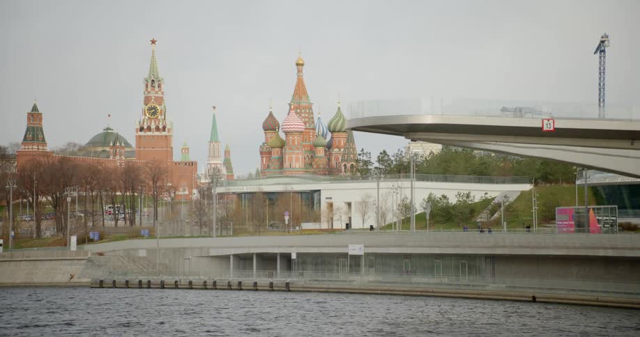 People walk past the water near the city