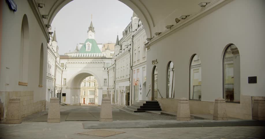 Arch covers driveway between ornate building wings
