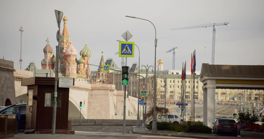 Cars drive on a city street with a large church