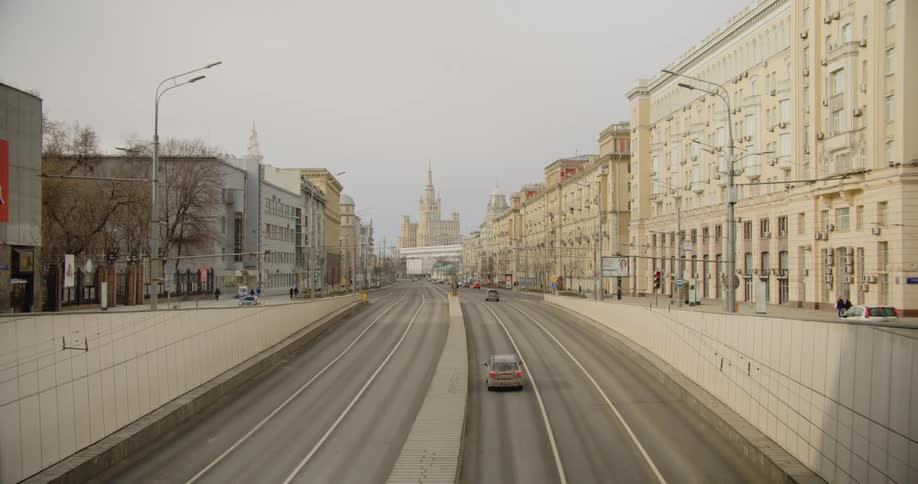 Few cars driving on city streets