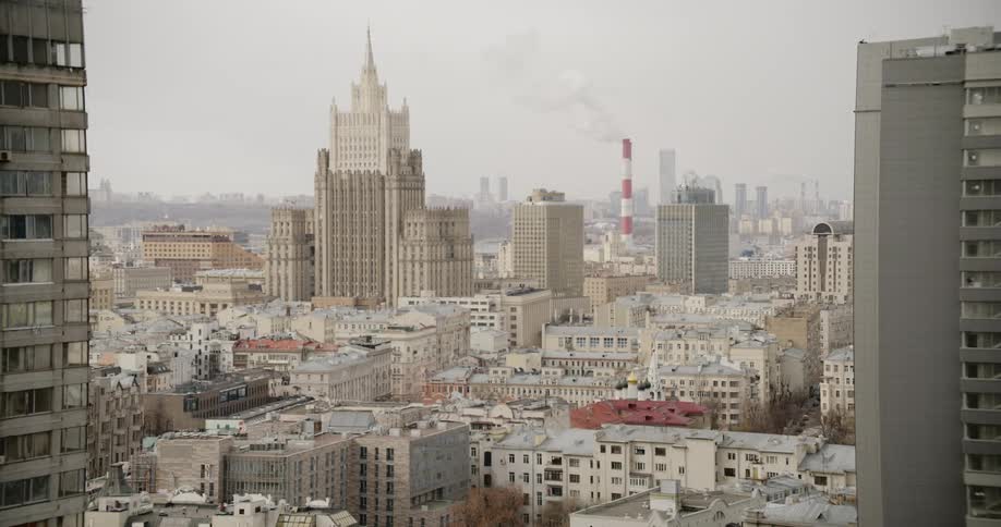 Smoke rises from a smokestack in middle of city