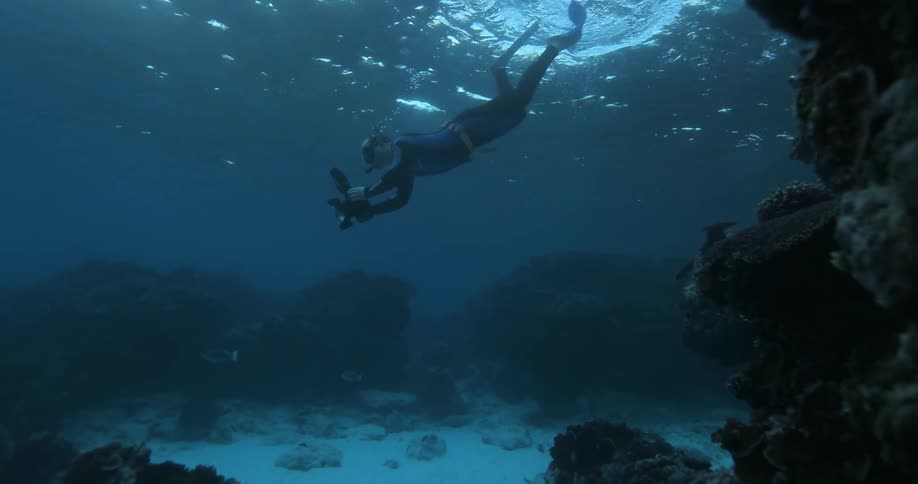 Diver swimming in the ocean with an underwater camera