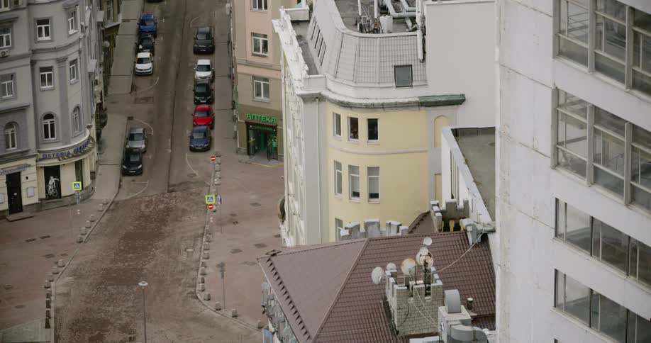 Cars are parked near a street empty of pedestrians