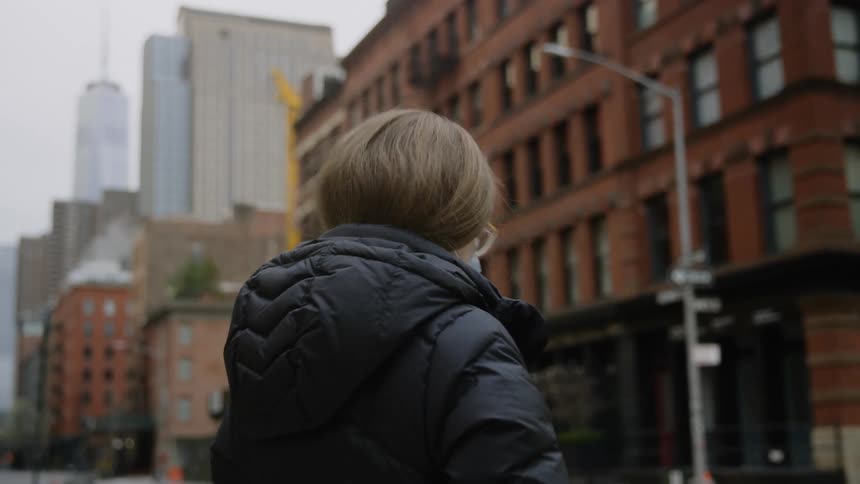 A woman in a mask walks on a city street