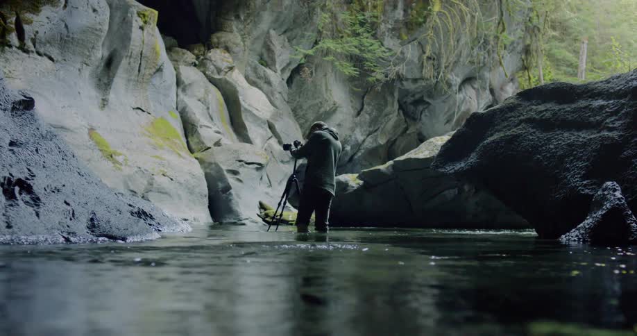 Man standing in the stream takes pictures