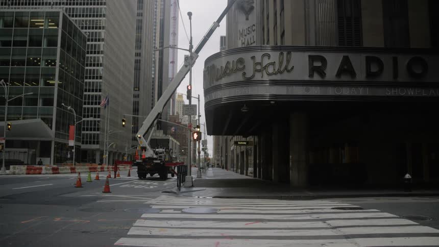 A construction vehicle is parked outside of a large building