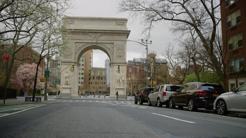 A single person walks a crosswalk in a large city
