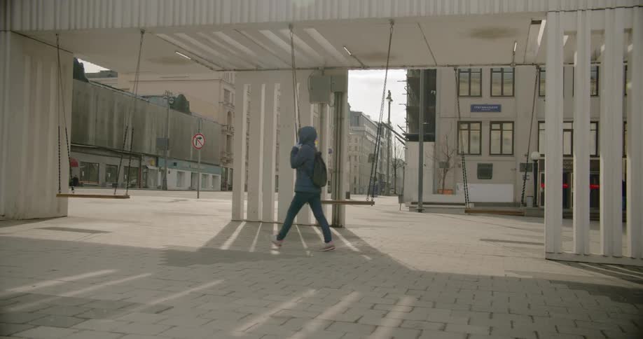 Woman wearing face mask walks on empty streets