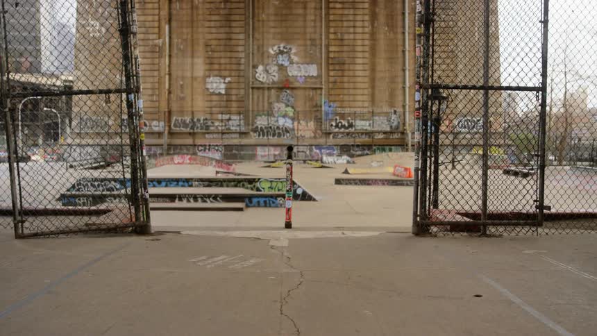 Fenced skating park under a bridge in a city