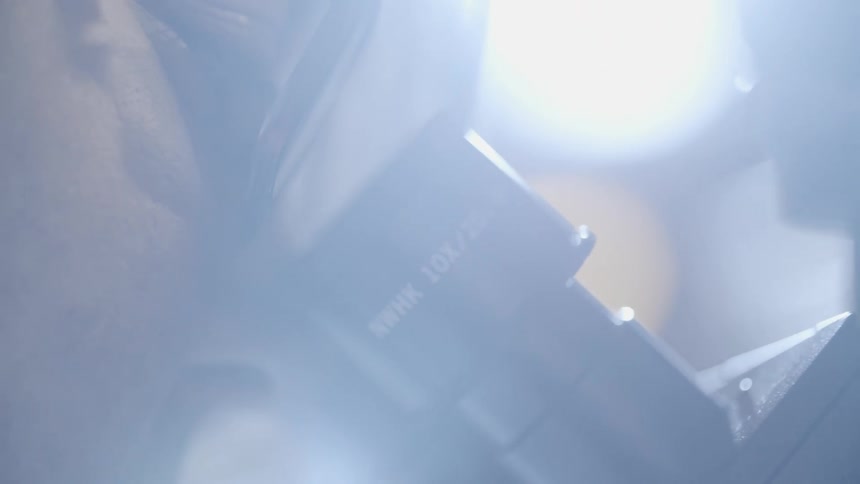 A woman looks into the microscope