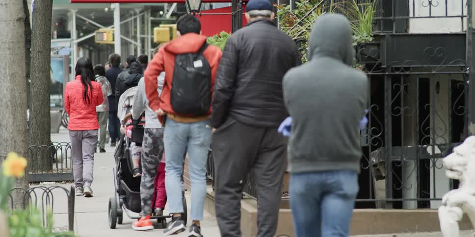 People traveling down a crowded sidewalk in a city