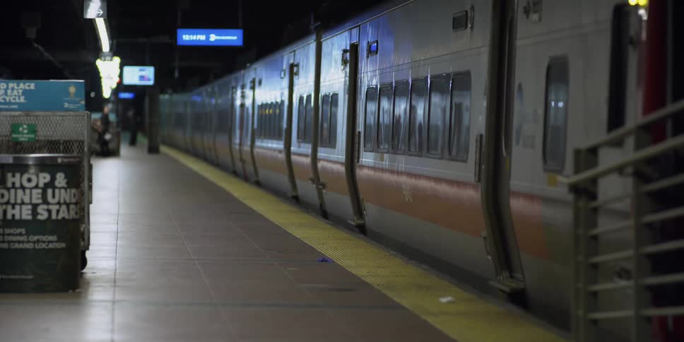 Two people wait at the entrance of a subway train