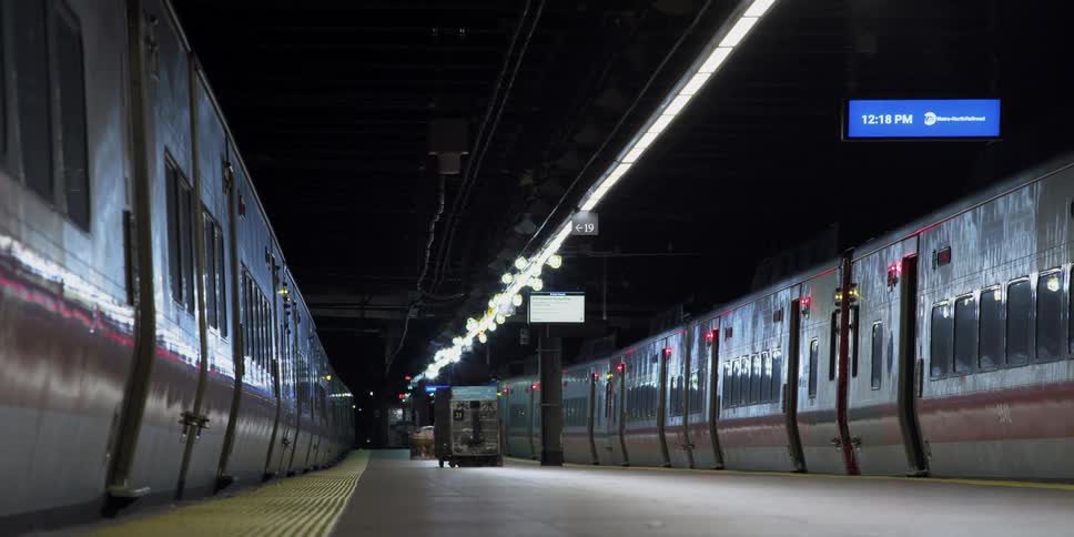 Two subway trains remains stopped and unoccupied near empty transit platform