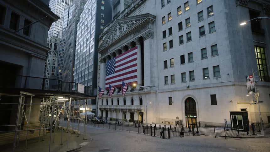 Large flags hang outside of a building in a downtown area