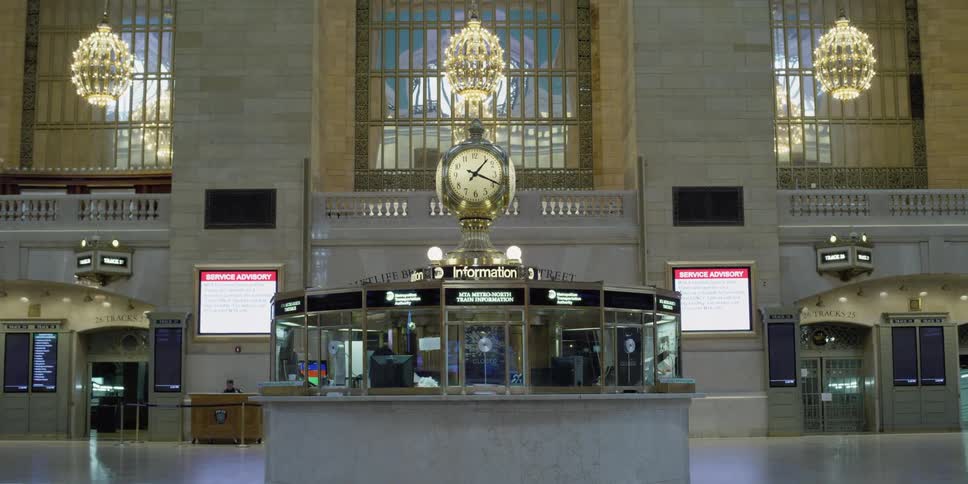 A train station terminal with signs and chandeliers