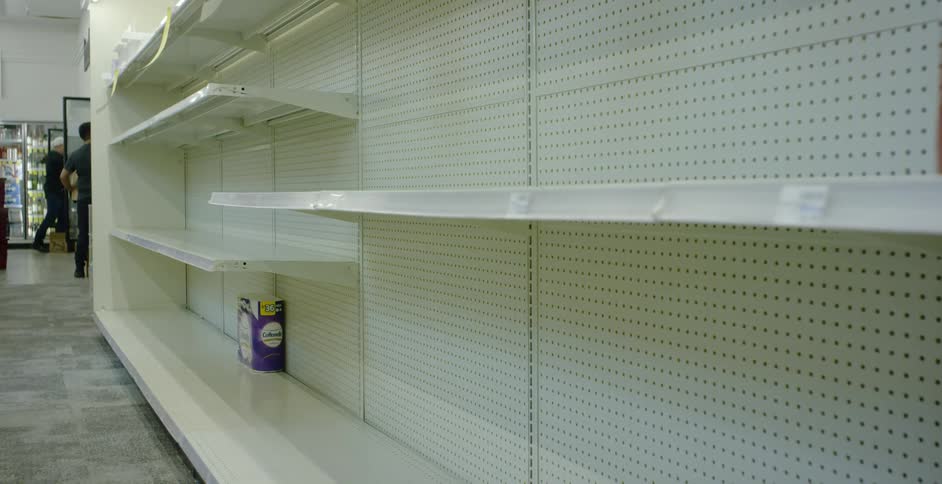 Nearly empty shelves of tissue in a store
