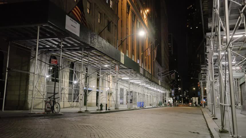 An empty city street with construction equipment on the store fronts