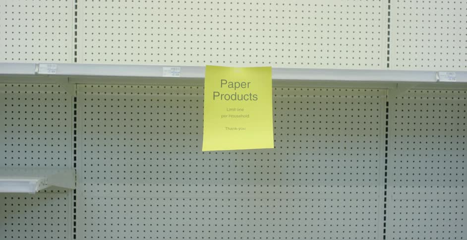 A sign hangs on an empty shelf in a store