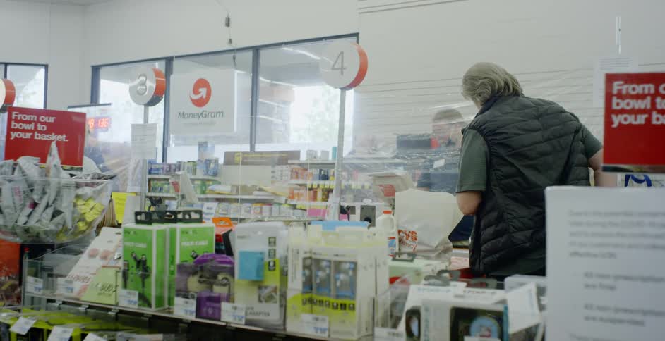 A man checks out at a register in a store