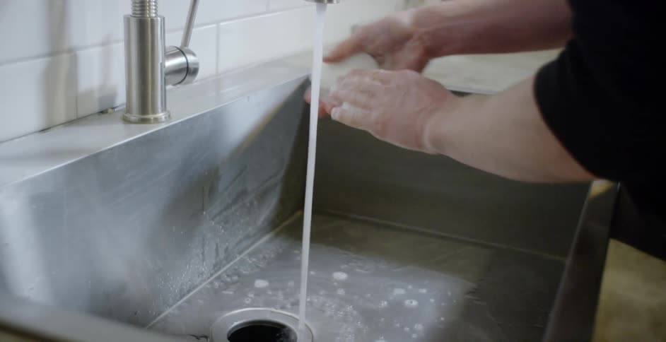 A person washing their hands in a sink