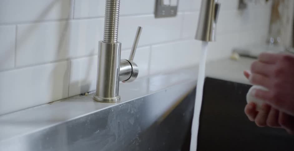 A person washing their hands in a sink
