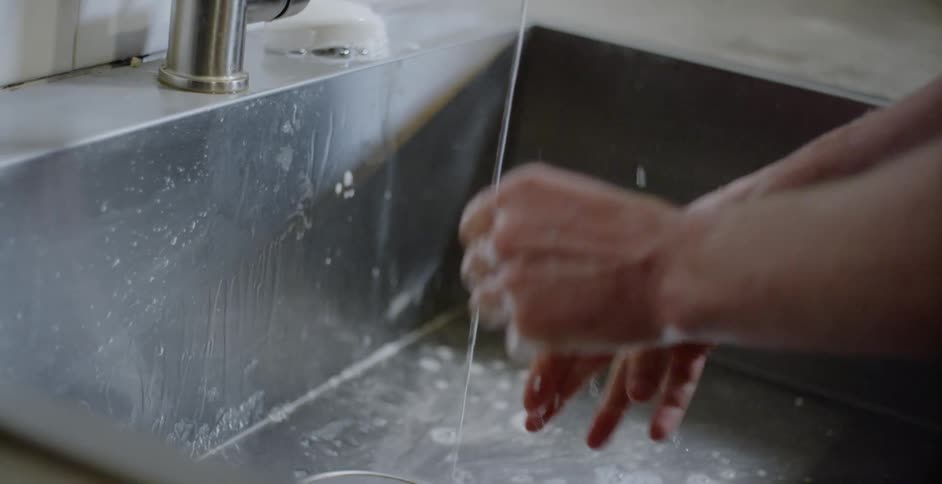 A person washing their hands in a sink