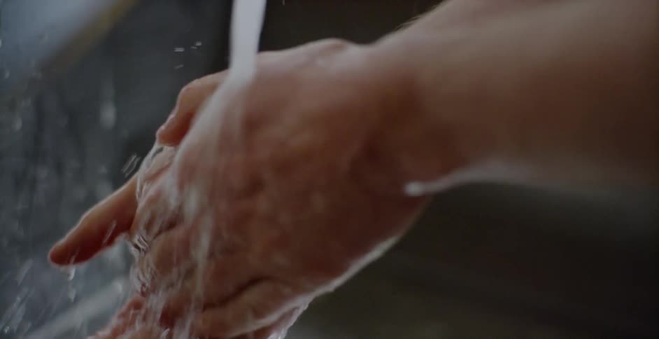 A person washing their hands in a sink