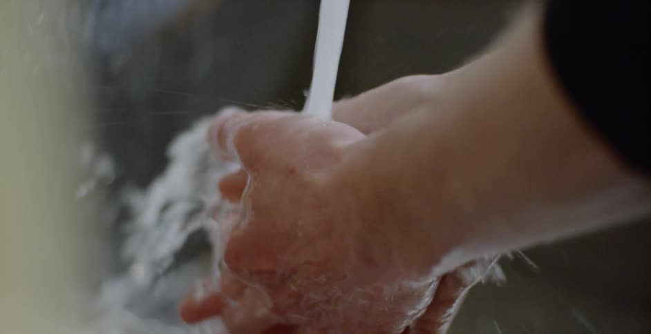A person washing their hands in a sink