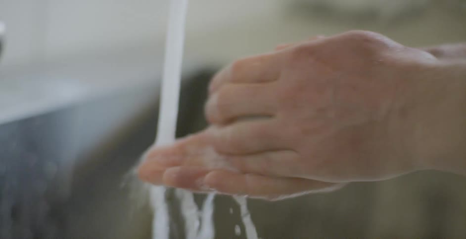A person is washing their hands with a bar of soap