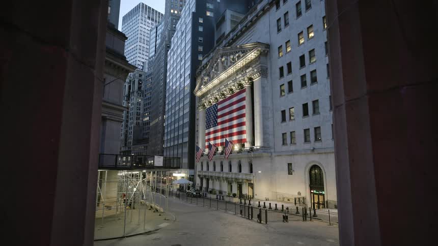 Large american flag occupies side of building on near empty downtown