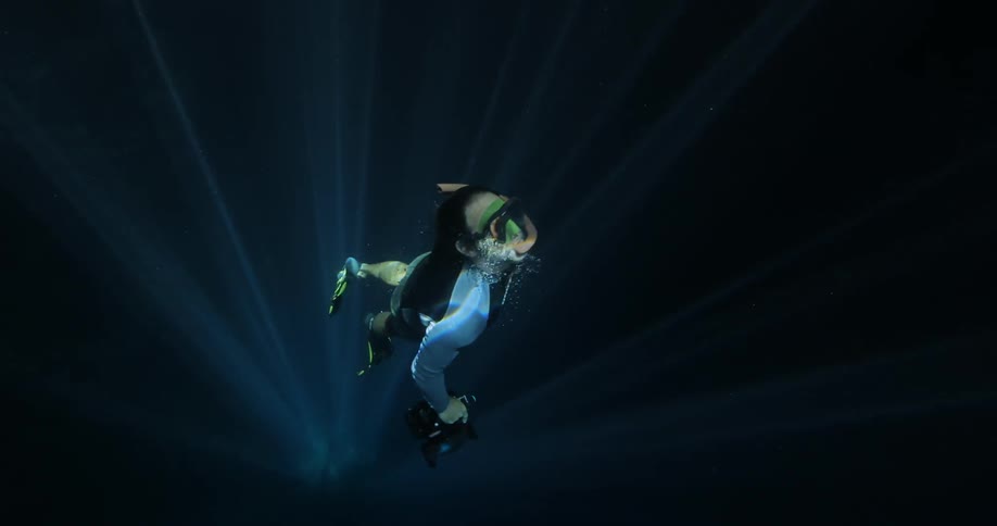 Person swims away from light
