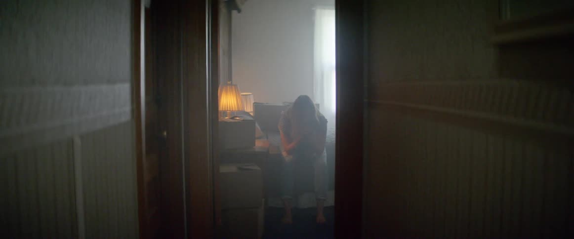 A woman is sitting on a bed indoors