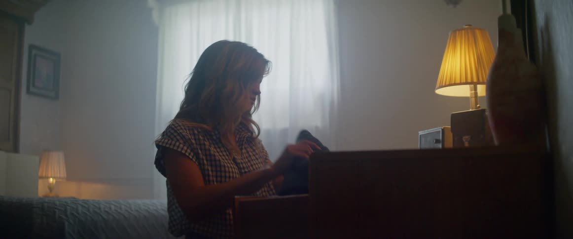 A teenager removes clothes from a dresser drawer
