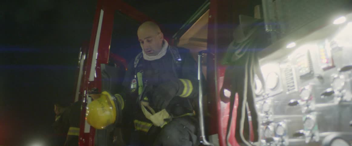 Two firemen get out of a fire truck