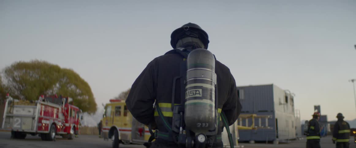 A firefighter walks towards the fire truck