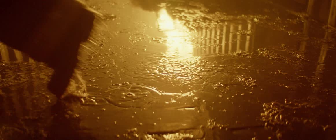 Firefighter walks on the puddle reflecting the fire at night