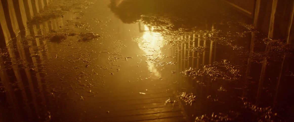 A puddle of water on the floor reflects a flaming fire