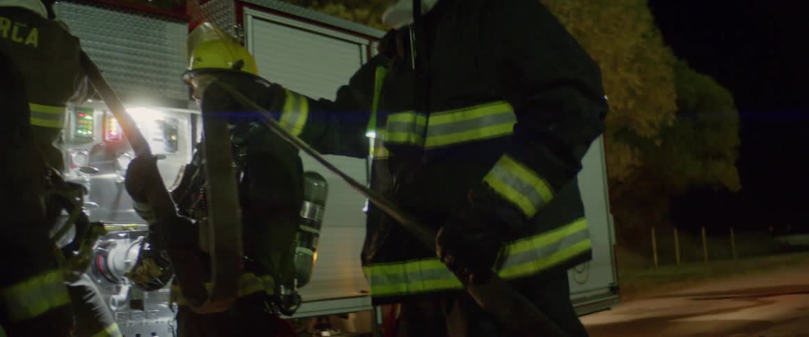 Fire fighters reel in the hose