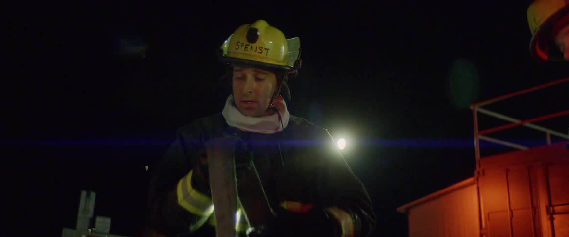 Firefighters straighten fire hose at night