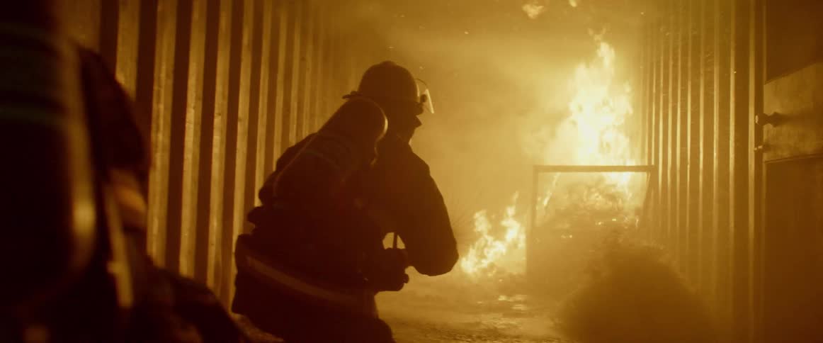 Firefighters enter a hallway to put out a fire in a building